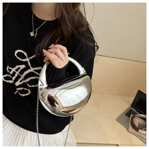 Détail d'un sac à main œuf en acrylique miroir argenté avec une fine chaîne métallique