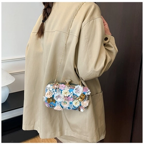 Detail showing colorful 3D floral appliques and sequins on the blue evening clutch bag