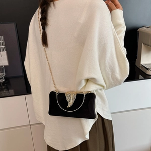 Elegant black velvet evening clutch with gold leaf clasp and metal chain strap