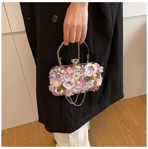 Detail of evening clutch with 3D flowers, sequins, and crystal heart-shaped clasp
