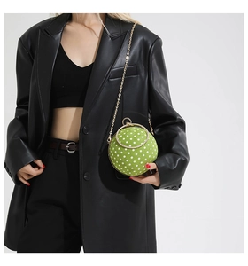 Close-up of green polka dot spherical bag with a rhinestone-encrusted metal handle