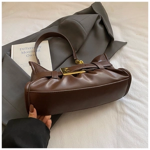 Detailed view of dark brown pleated tote bag with vintage golden square buckle and glossy finish