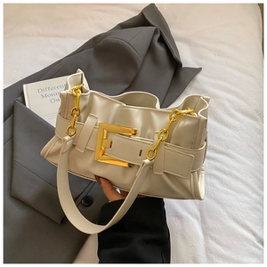 Detail of cream pleated cloud bag with large gold buckle and side chain accent