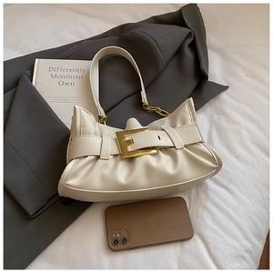 Close-up of cream pleated shoulder bag with gold square buckle and chain strap detail