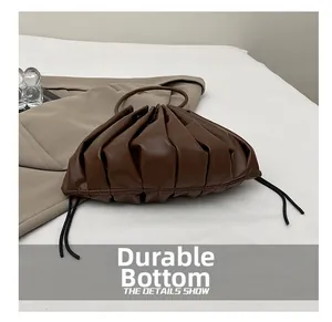 Detailed close-up of brown ruched dumpling bag showing high-quality leather texture