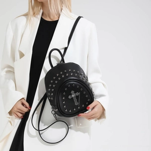 Detail of black mini rivet backpack with gothic cross pendant and silver studs
