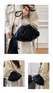 Detailed view of the black pleated cloud bag texture and flexible drawstring closure