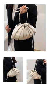 Close-up of cream pleated cloud bag showing soft leather texture and drawstring detail