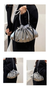 Detail of silver metallic pleated cloud bucket bag with drawstring and top handle