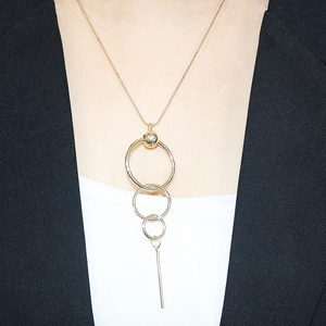 Modern gold long necklace with concentric rings and bar pendant on a female model
