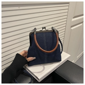 Detailed close-up of blue denim doctor bag with brown vintage handles and white stitching