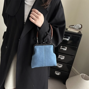 Retro denim kiss-lock crossbody bag with unique brown ring handle and silver hardware