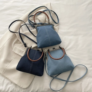 Retro denim patchwork kiss-lock bag with wooden handle and crossbody strap in three blue tones