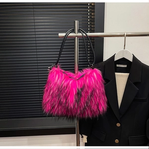 Close-up of vibrant pink faux fur shoulder bag with textured black long straps