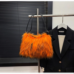 Macro detail of plush orange faux fur texture and black rope strap on shoulder bag