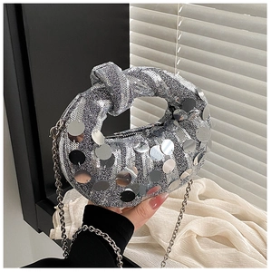 Detail of silver sequin dumpling bag with knotted handle and elegant chain strap