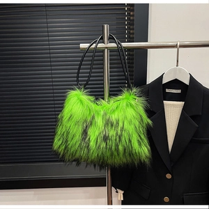 Detail of neon green faux fur texture and black leather shoulder strap on a handbag