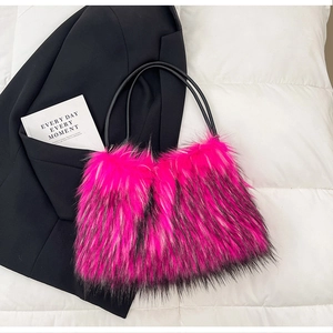 Gros plan d'un sac en fausse fourrure rose et noire sur fond blanc matelassé