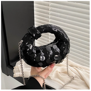 Detailed view of black sequined wrist bag featuring chunky circular paillettes and chain