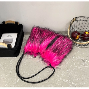 Détail d'un sac bandoulière en fausse fourrure fuchsia et noire avec de fines lanières