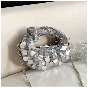 Detail of silver sequined dumpling bag with mirror metal discs and a knotted handle