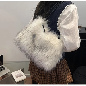 Détail du sac fourre-tout en fausse fourrure blanche avec anses noires et texture duveteuse