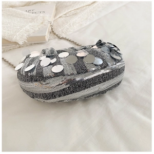 Macro shot of silver sequin handbag texture with large round reflective metal plates