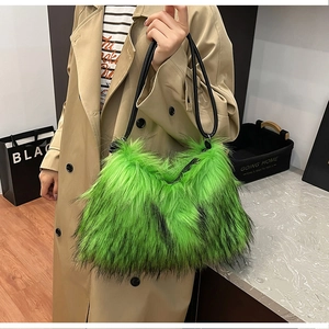Détail d'un grand sac à main en fausse fourrure verte porté à l'épaule sur un manteau
