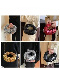 Detail of sequined mini evening bag showing knotted handle and silver metallic chain strap