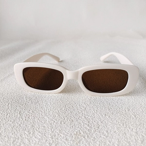 Vue à plat de lunettes de soleil rétro pour enfants avec monture blanche et verres bruns