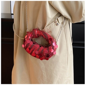 Macro detail of red sequin evening clutch bag with chic metallic chain strap