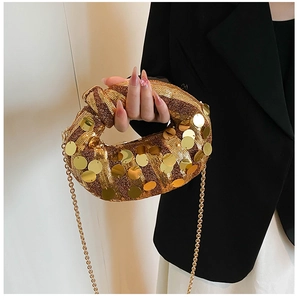 Close-up of golden sequin evening clutch with knot handle and elegant metal chain strap