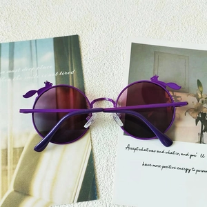 Detailansicht der lila runden Kinder-Sonnenbrille mit niedlichen Eichhörnchen-Verzierungen