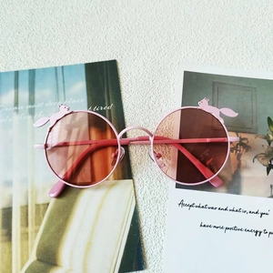 Makro-Detail der rosa runden Kinder-Sonnenbrille mit süßem Eichhörnchen auf einer Lifestyle-Karte