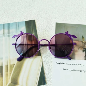 Detail einer lila runden Kinder-Sonnenbrille mit niedlichen Tierakzenten und Gläsern