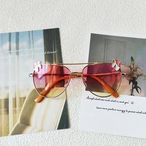 Détail de lunettes aviateur roses pour enfants avec licorne sur monture dorée élégante