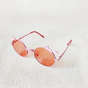 Detail of pink round kids sunglasses featuring cute cartoon animal ears on the frame