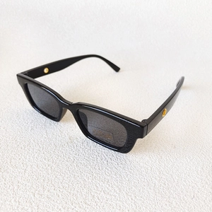 Detailed close-up of black square sunglasses featuring UV400 CE certified lenses
