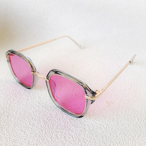 Vue détaillée des lunettes de soleil vintage pour enfants avec verres roses et branches dorées
