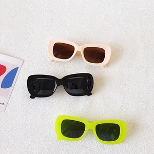Three pairs of vintage oval wide-frame sunglasses in pink, black, and neon green colors