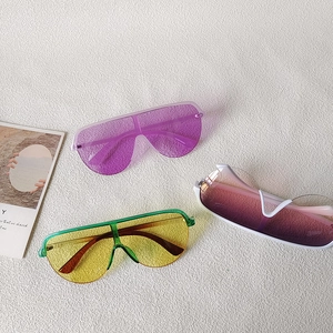 Oversized wrap-around sunglasses in multiple trendy colors on a minimalist background