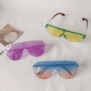 Flat lay of colorful oversized flat top sunglasses with seamless lenses in three various colors