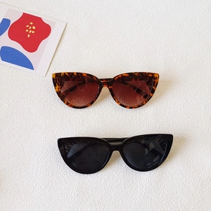 Classic cat eye sunglasses in black and tortoise shell patterns on a white background