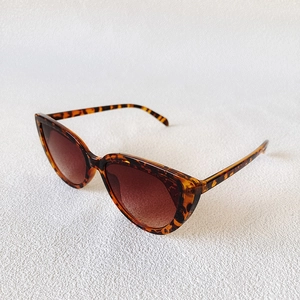 Close-up of tortoise shell cat eye sunglasses with brown gradient lenses and brow detail