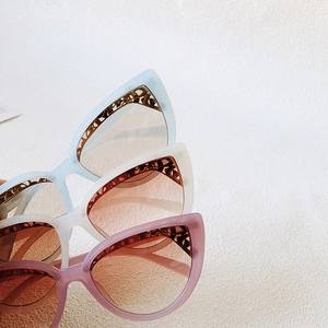 Close-up of cat-eye sunglasses featuring intricate metal wire eyebrow decoration details