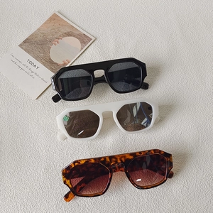 Detailed flat lay of oversized retro sunglasses in black, cream, and leopard print patterns