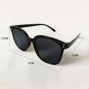 Détail des lunettes de soleil rondes noires avec rivets argentés et mesures de la monture