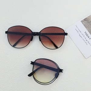 Macro view of compact foldable sunglasses with gradient lenses in black frames