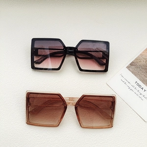 Fashionable oversized square sunglasses with gradient lenses in black and transparent tea frames