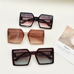 Detailed flat lay of oversized square sunglasses in black, brown and gradient purple tones